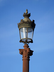 Parisian antique street lamp in Concorde Square on blue sky background
