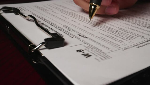 16 hispanic male hand filling out writing w9 irs tax form document