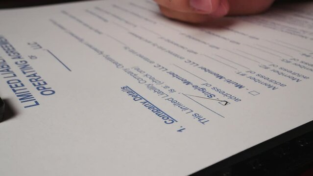 23 hispanic male hand filling out member limited liability LLC contract