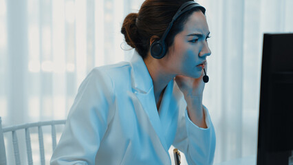 Businesswoman wearing headset working in office to support remote customer or colleague. Frustrated...