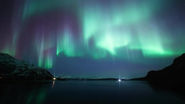An unusually bright aurora dancing above a reflective fjord in northern Norway on March 3rd, 2024.