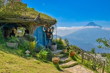 Girl posing in front of Hobbit House in Hobbitenango, Guatemala. - obrazy, fototapety, plakaty