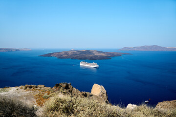 Cruise ship in front of the volcanic island of Nea Kameni in Thira, Santorini, Greece