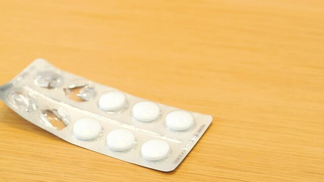 An open package of pills is on the table. White pills, quick help, home treatment