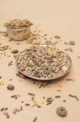 2 bowls with food for rodents, a lot of scattered pellets. food for rodents like rabbits, guinea pigs, hamsters, rats, mice, chinchilla, degu, squirrels.
