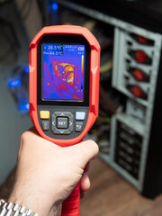 Checking the heating of computer components using a thermal imager. A thermal imaging camera held...