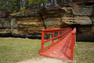 A red man-made bridge leads into a rock tunnel at Pier County Park in Rockbridge, Wisconsin a...