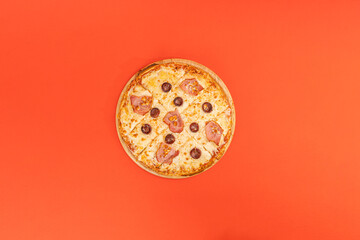 pizza with cheese beacon and olives on orange background