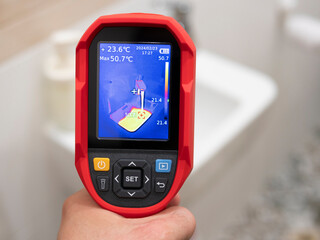 Thermal imaging inspection of heating equipment. A worker checks the temperature of the water in...