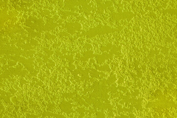 Bright acid vibrant light yellow paint plaster wall abstract pattern background design texture