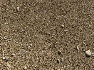 Fine beach sand with stones polished by the sea.