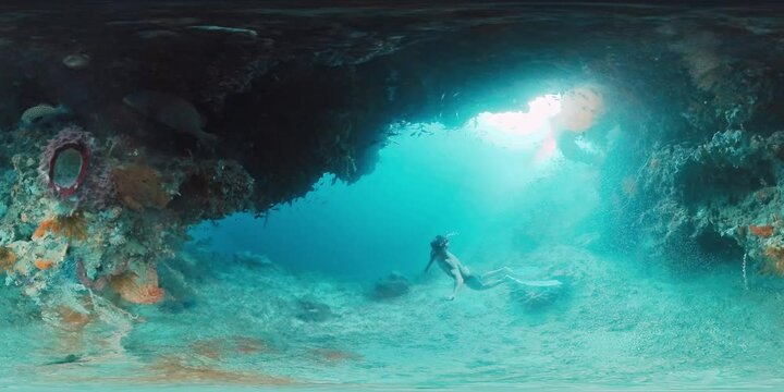 360 vr footage of the freediver swimming underwater in the tropical sea and exploring intricate seascape and abundant marine life of the West Papua region in Indonesia