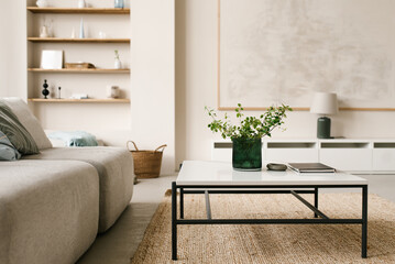 Stylish modern coffee table with metal legs and natural stone table top, modular sofa in light...