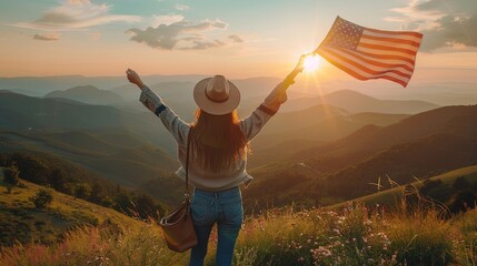 Happy woman with USA flag on top of the mountain at sunset
