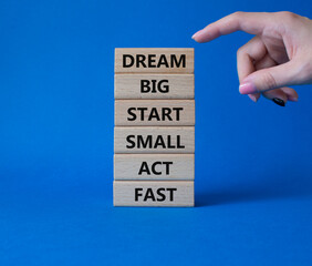 Dream Big Start Small Act Fast symbol. Concept words Dream Big Start Small Act Fast on wooden blocks. Businessman hand. Beautiful blue background. Business concept. Copy space.
