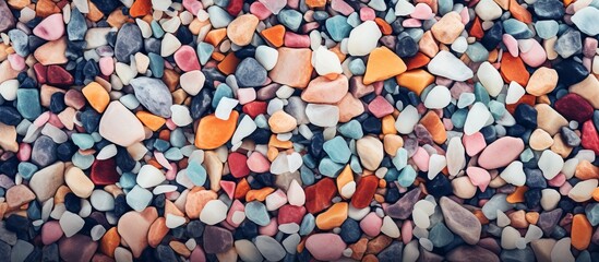 A colorful pile of rocks stacked on top of each other in a fun and artistic gesture, creating a vibrant display of magenta and other bright hues, drawing a crowd at an outdoor event - obrazy, fototapety, plakaty