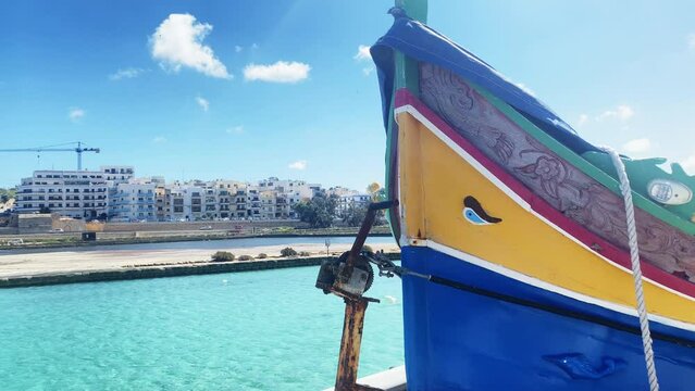 Close up of colorful Maltese boat with eye in Qawra bay. Maltese Luzzu fishing boat. High quality 4k footage