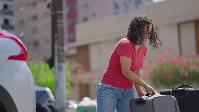 Happy couple puts his suitcase in the back of the car and prepares to leave for trip. Husband and wife open the back of the car put luggage travel. Couple moving into new home at moving day
