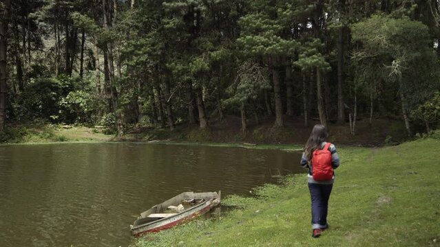 young woman walking beside a lake, exploring hiking, hiking, hipster woman exercising