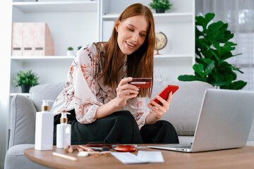 Young happy woman buy product by online shopping at home while ordering items from the internet...