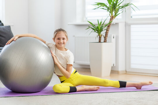 Cheerful Child with Fitness Ball on Yoga Mat
