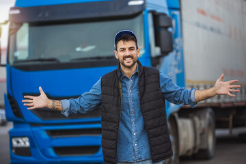 Happy confident male driver standing in front on his long vehicle ready to drive.