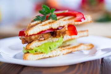 fried toast with chicken, salad, greens on a wooden table