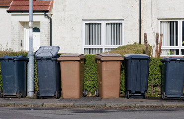 Fototapeta na wymiar Wheelie bins in row for refuge collection outside council residential building