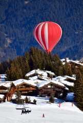 Red Hot air balloon on the slopes of Courchevel ski resort by winter