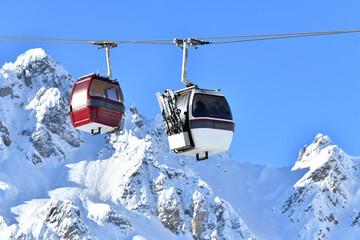 Vintage ski gondolas over slopes of French Alps by winter