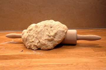 Rolling pin with dough for bread or cakes. Kitchen.