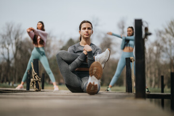 Focused female athletes engaging in a stretching routine outdoors, showcasing fitness and health.