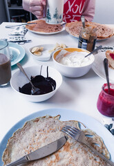 Breakfast with pancakes, jam, ice cream and fruits on white table. Family time