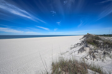 St. Andrews State Park reveals its pristine beauty with emerald-blue waters meeting white sands under a clear blue sky, a perfect harmony of colors and tranquility.