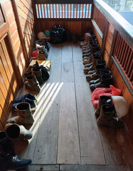 a collection of boots neatly lined up on the wooden floor