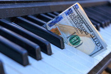 A keyboard with a $100 bill on it