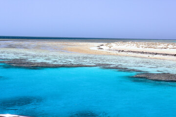 Captivating view of Egypt's Red Sea coral reef near Marsa Alam, Hamata Islands. Crystal-clear turquoise waters under a warm, sunny sky.