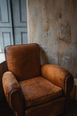 old grunge leather chair by rusty wall, vintage classic armchair