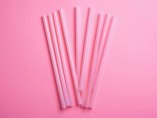 Eco-friendly option: Reusable plastic straw on pink background in flat lay.
