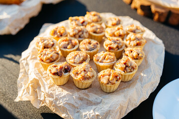 Mini Quiches on Parchment for Event Catering. Savory mini quiches with melted cheese on top,...