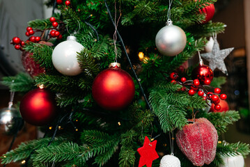 Decorated Christmas Tree with Festive Ornaments. A richly adorned Christmas tree with shiny red and white baubles, berry clusters, and twinkling lights, capturing the spirit of the holiday season.