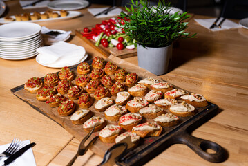 Assorted Bruschetta on a Rustic Wooden Board. A selection of bruschetta toppings, including tomato...