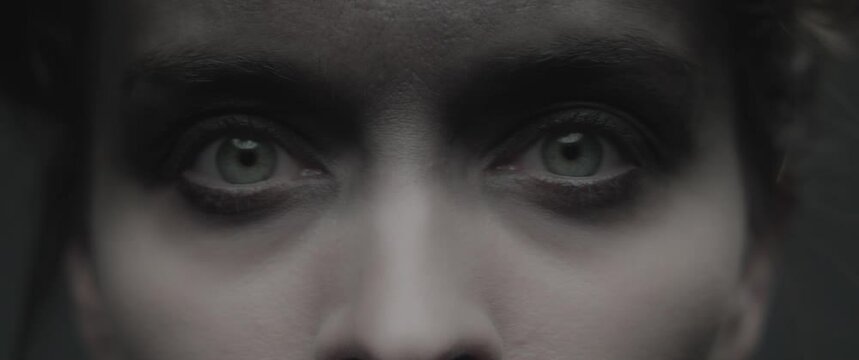 A woman dressed as mother nature looks into the camera and opens her eyes wide