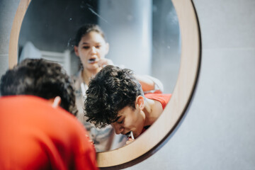 A young adult attentively grooming in front of a circular mirror, capturing everyday hygiene practices.