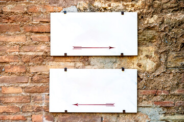 Empty Signs with Arrows on Unplastered House Wall for Custom Labeling