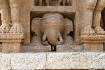 Fototapeta na wymiar Elephant statue in ancient temple. Sandstone carving of animal sculpture with ancient Tamil inscription at the wall in Kanchi Kailasanathar temple in Kanchipuram, Tamilnadu.
