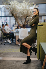 A confident and successful business person standing in a modern office. This proud and professional executive portrays a positive and happy leader of a company.
