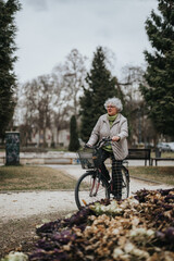 Fototapeta premium An independent mature woman leisurely cycling through a tranquil park setting, embracing an active lifestyle.
