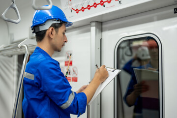 Maintenance crew in uniforms and helmets are methodically inspecting the interior of an empty train...