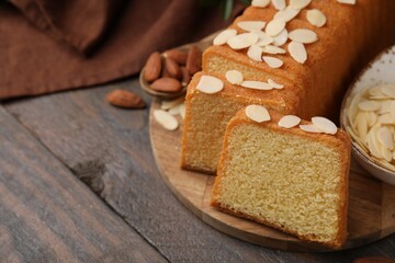 Fototapeta na wymiar Cake with fresh almond flakes on wooden table, closeup. Space for text